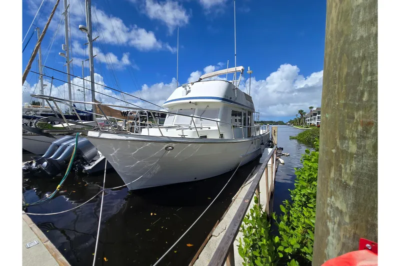 The Image of 1983 Custom Present 38 Double Cabin Trawler docked under a clear blue sky. - 0