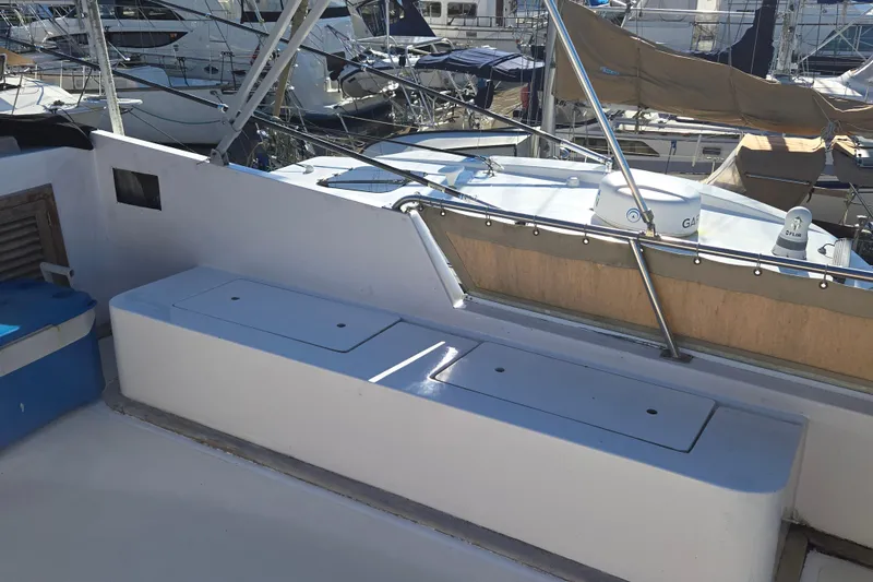 Slide: The Image of 1983 Custom Present 38 Double Cabin Trawler deck with storage compartments and marina view. - 10