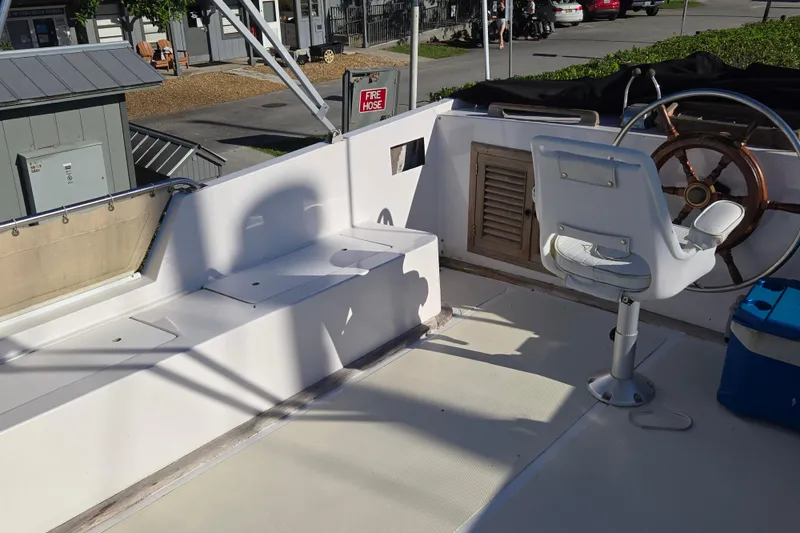 Slide: The Image of 1983 Custom Present 38 Double Cabin Trawler helm with steering wheel and seating. - 11
