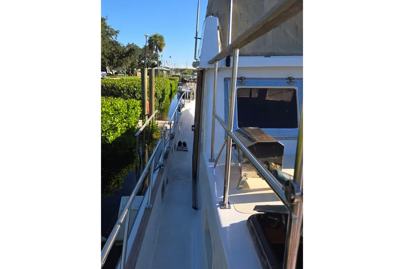 Slide: The Image of 1983 Custom Present 38 Double Cabin Trawler docked, side view with clear blue sky. - 14