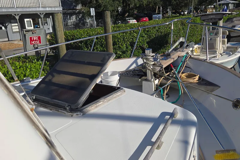 Slide: The Image of 1983 Custom Present 38 Double Cabin Trawler deck with open hatch and mooring equipment. - 16