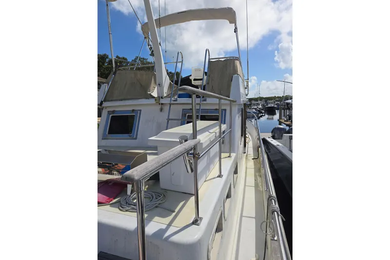 Slide: The Image of 1983 Custom Present 38 Double Cabin Trawler docked, showcasing deck and railing details. - 5