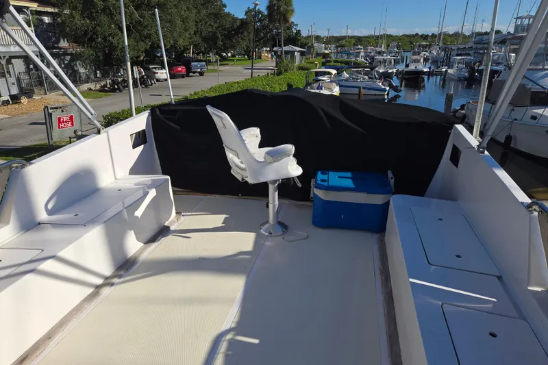 Slide: The Image of 1983 Custom Present 38 Double Cabin Trawler deck with seating and cooler, docked at marina. - 8