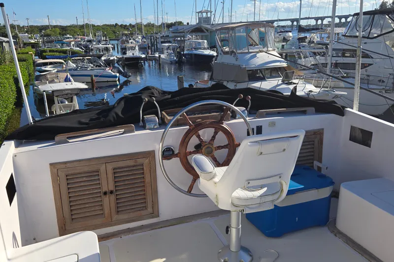 Slide: The Image of Helm of 1983 Custom Present 38 Double Cabin Trawler in marina setting. - 9