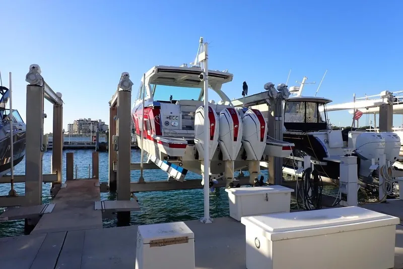 Slide: The Image of 2023 Formula 380 Super Sport Crossover OB docked at marina with multiple outboard engines. - 2