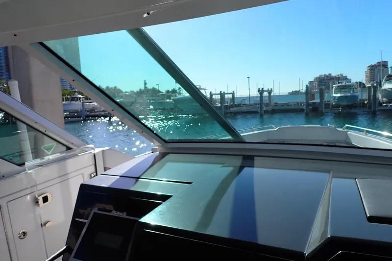Slide: The Image of 2023 Formula 380 Super Sport Crossover OB helm view with marina backdrop. - 8
