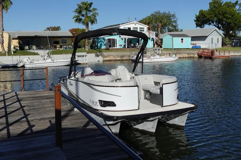 Slide: The Image of 2020 Tahoe Pontoon 2485 LTZ Rear Lounger docked by waterfront homes. - 10