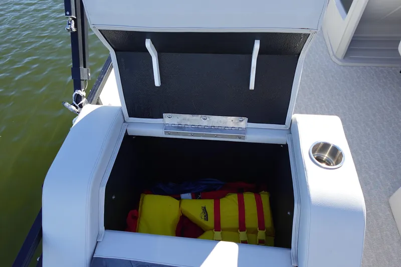 Slide: The Image of Open storage compartment on 2020 Tahoe Pontoon 2485 LTZ, revealing life jackets inside. - 17