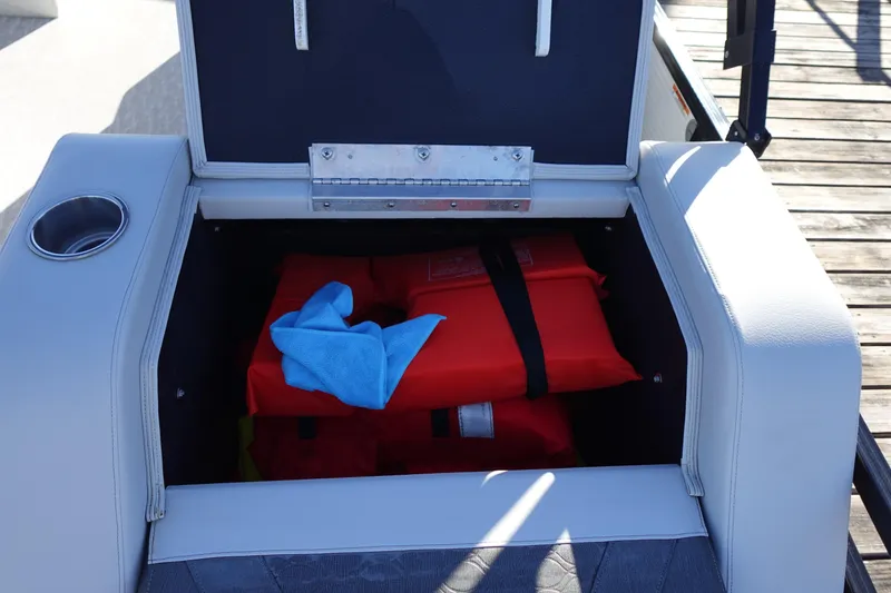Slide: The Image of Storage compartment on 2020 Tahoe Pontoon 2485 LTZ, containing life jackets and a blue cloth. - 21