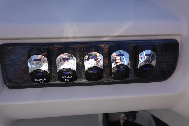 Slide: The Image of Control panel of 2020 Tahoe Pontoon 2485 LTZ Rear Lounger with labeled switches. - 28