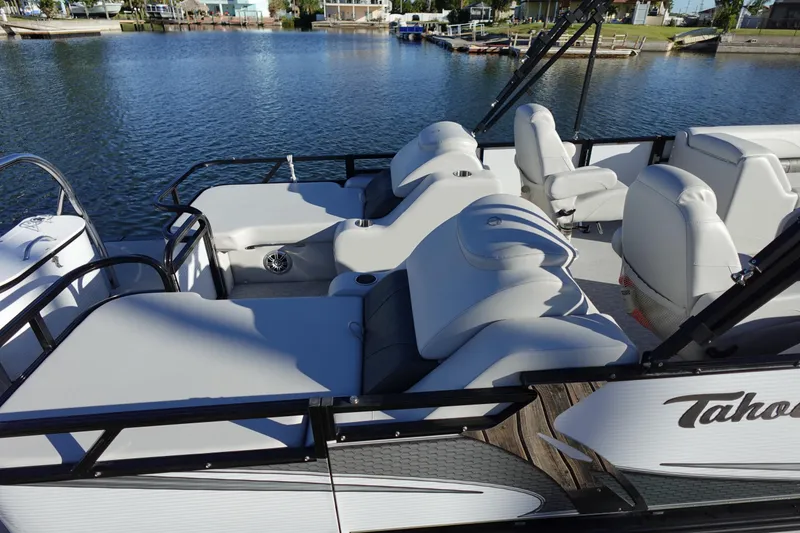 Slide: The Image of 2020 Tahoe Pontoon 2485 LTZ Rear Lounger on calm water, showcasing luxurious seating. - 45