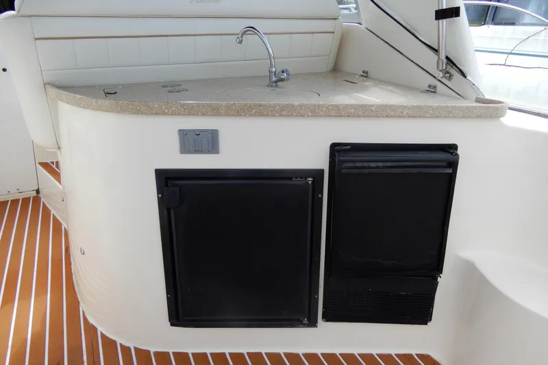 Slide: The Image of 2005 Rinker 360 Express Cruiser kitchenette with sink and mini fridge. - 10