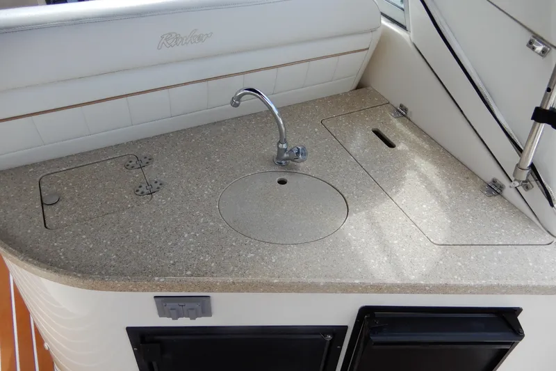 Slide: The Image of 2005 Rinker 360 Express Cruiser kitchenette with sink and storage compartments. - 11