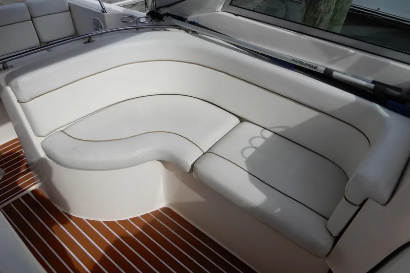Slide: The Image of 2005 Rinker 360 Express Cruiser interior with white seating and wood-patterned flooring. - 15