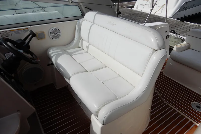Slide: The Image of 2005 Rinker 360 Express Cruiser interior with white seating and steering wheel. - 16