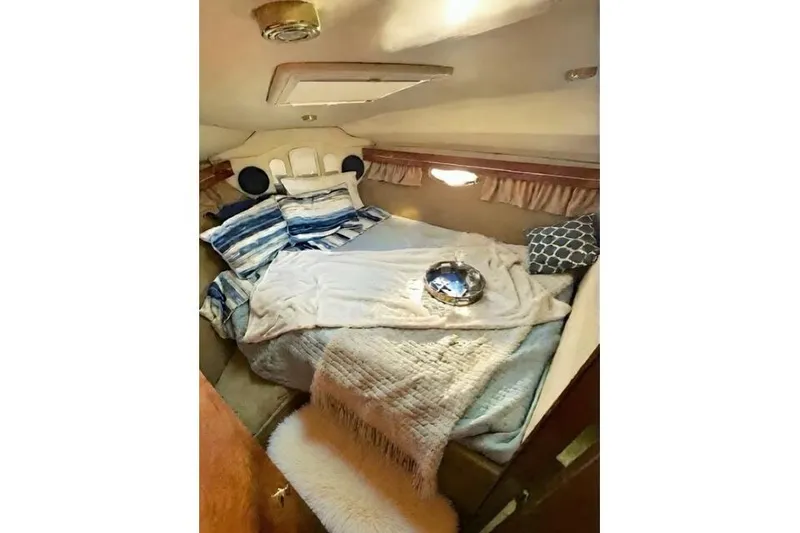 Slide: The Image of Cozy cabin interior of 2005 Rinker 360 Express Cruiser with plush bedding and soft lighting. - 21