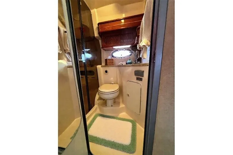 Slide: The Image of 2005 Rinker 360 Express Cruiser bathroom with toilet, shower, and porthole window. - 23