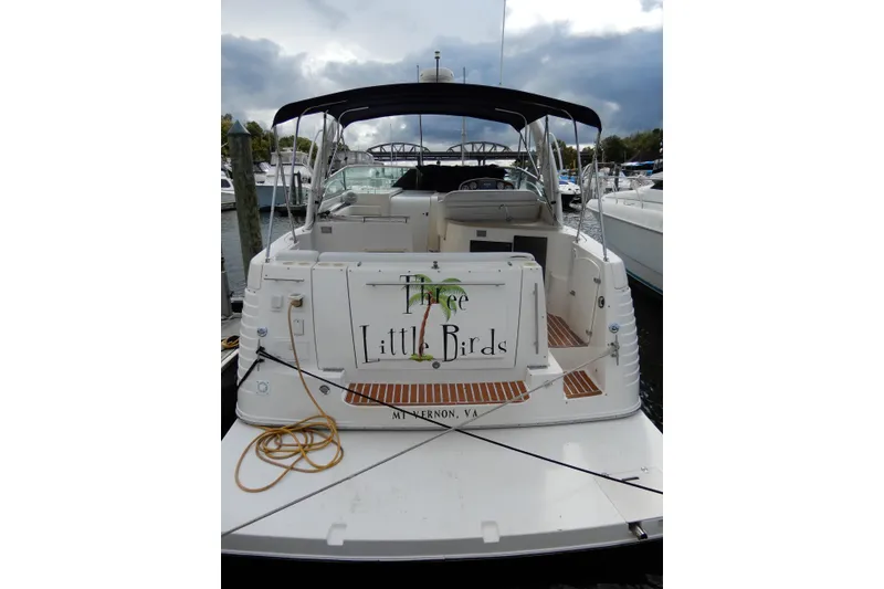 Slide: The Image of 2005 Rinker 360 Express Cruiser docked, rear view with "Three Little Birds" signage. - 4