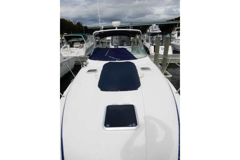 Slide: The Image of 2005 Rinker 360 Express Cruiser docked at a marina under cloudy skies. - 5