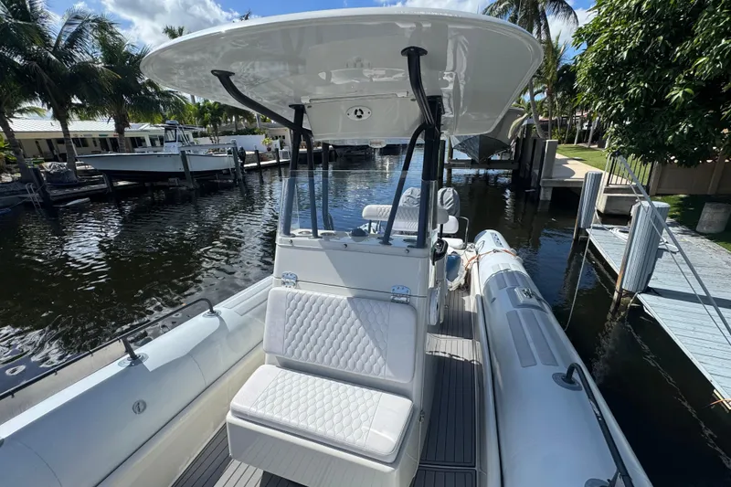 Slide: The Image of 2014 Zodiac 850 boat docked by palm trees, featuring a sleek design and comfortable seating. - 3