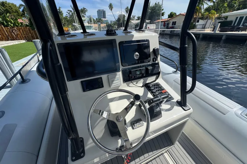 Slide: The Image of Control panel of a 2014 Zodiac 850 boat with steering wheel and navigation equipment. - 6