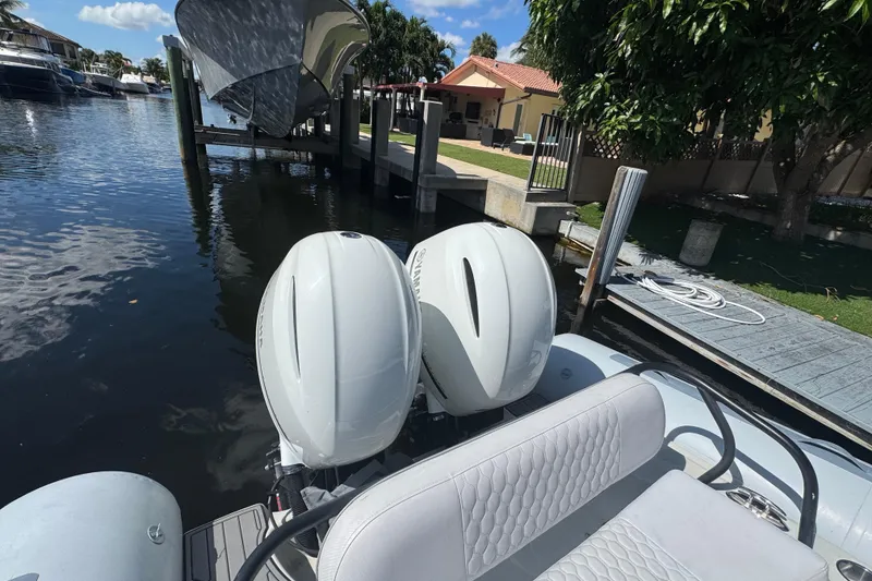 Slide: The Image of Zodiac 850 boat with dual outboard motors docked by a waterfront home, 2014 model. - 7
