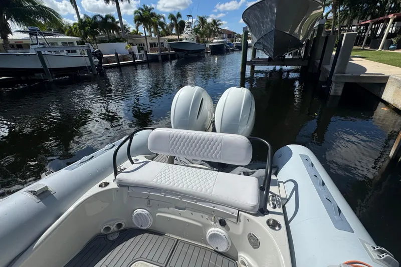 Slide: The Image of 2014 Zodiac 850 boat docked in a sunny marina with twin engines. - 8