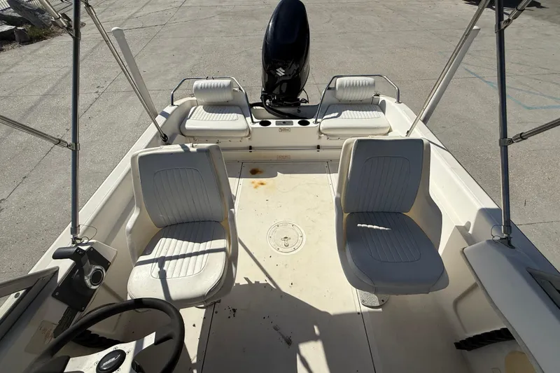Slide: The Image of 2002 Boston Whaler Ventura 160 boat interior with seating and steering wheel. - 12