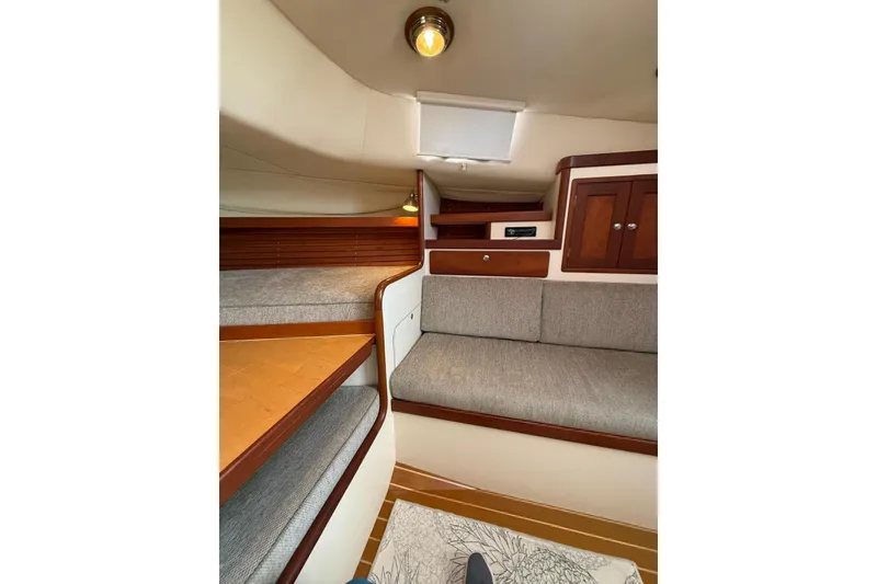 Slide: The Image of Interior of 2000 Little Harbor Whisper Jet 34, featuring cozy seating and wooden cabinetry. - 18