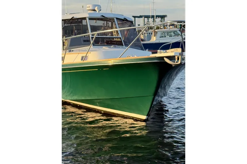 Slide: The Image of Little Harbor Whisper Jet 34, 2000 model, green hull, docked on calm water. - 26