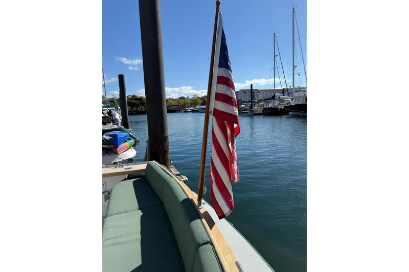 Slide: The Image of Little Harbor Whisper Jet 34, 2000 model, docked with American flag, sunny marina view. - 32