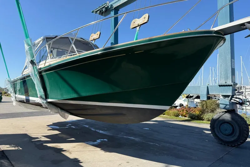 Slide: The Image of 2000 Little Harbor Whisper Jet 34 boat lifted in marina, green hull, clear sky. - 33