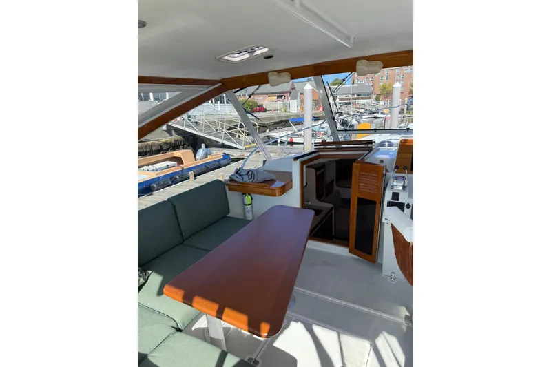 Slide: The Image of Interior view of 2000 Little Harbor Whisper Jet 34, featuring seating and wooden table. - 4