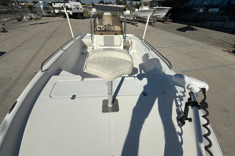 Slide: The Image of 2002 Fishmaster 196 Travis Edition boat with seating and steering console, parked outdoors. - 10