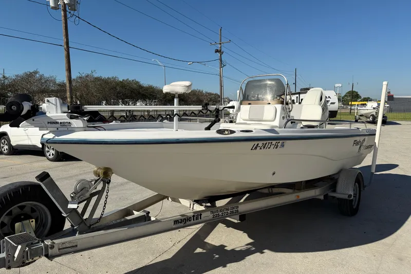 Slide: The Image of 2002 Fishmaster 196 Travis Edition boat on trailer, parked outdoors under clear sky. - 5