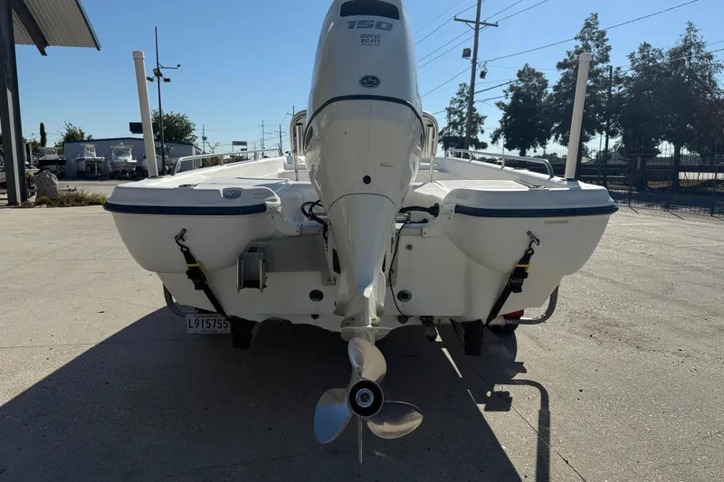 Slide: The Image of 2002 Fishmaster 196 Travis Edition boat with outboard motor, parked outdoors. - 7