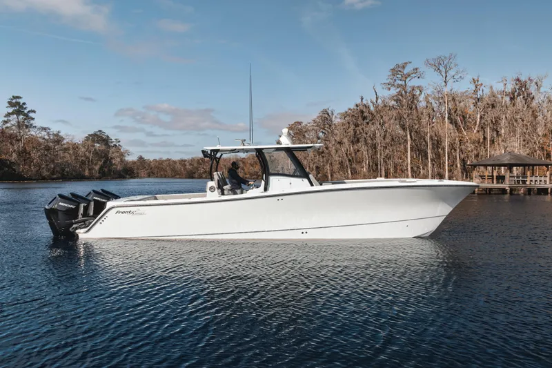 The Image of 2026 Front Runner 37' Catamaran on serene lake with wooded shoreline backdrop. - 0