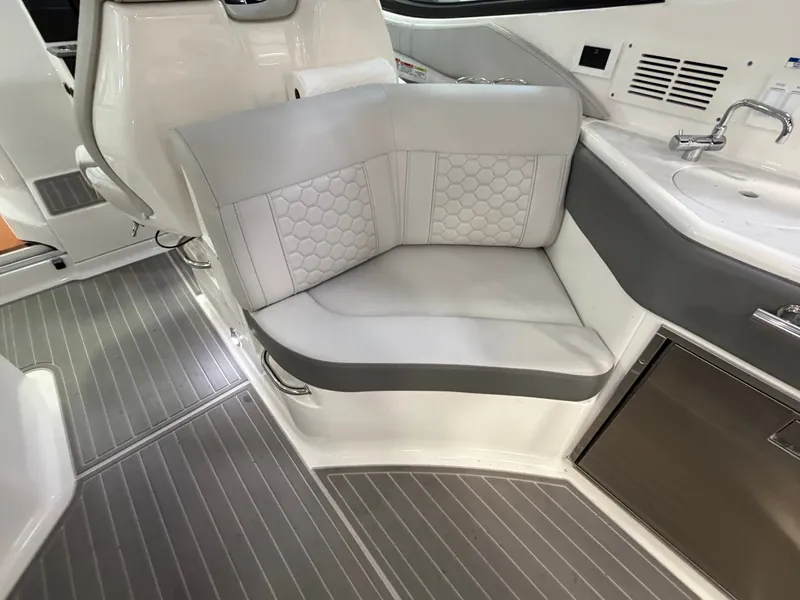 Slide: The Image of 2023 Sea Ray Sundancer 320 Outboard interior with gray seating and kitchenette. - 14