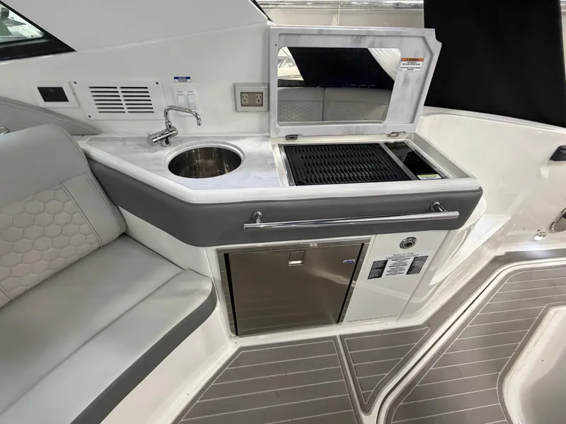 Slide: The Image of 2023 Sea Ray Sundancer 320 Outboard interior with kitchenette, sink, and grill. - 15