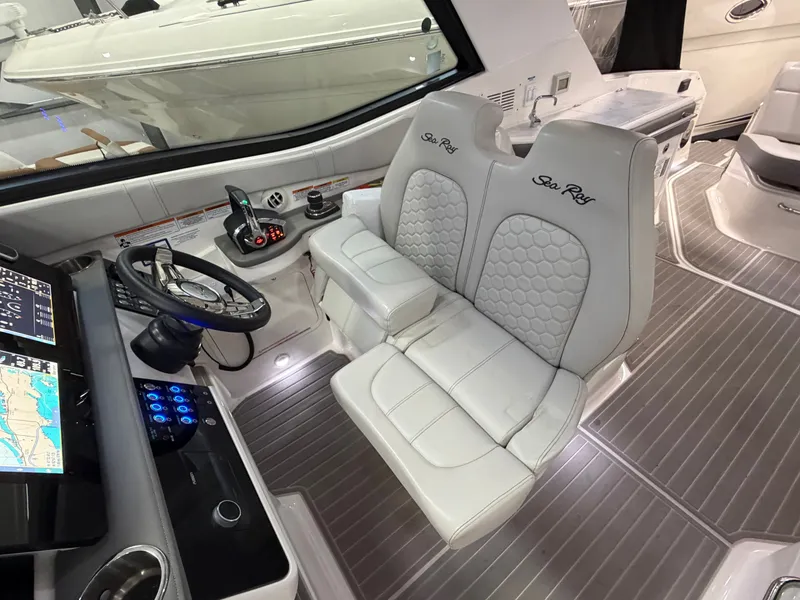 Slide: The Image of 2023 Sea Ray Sundancer 320 Outboard cockpit with dual seats and advanced navigation controls. - 17