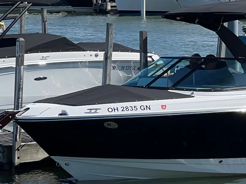 The Image of 2024 Sea Ray 280 SLX OB boat docked at marina, reflecting on calm water. - 0