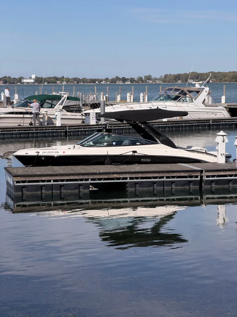 Slide: The Image of 2024 Sea Ray 280 SLX OB boat in a showroom, showcasing sleek black and white design. - 32