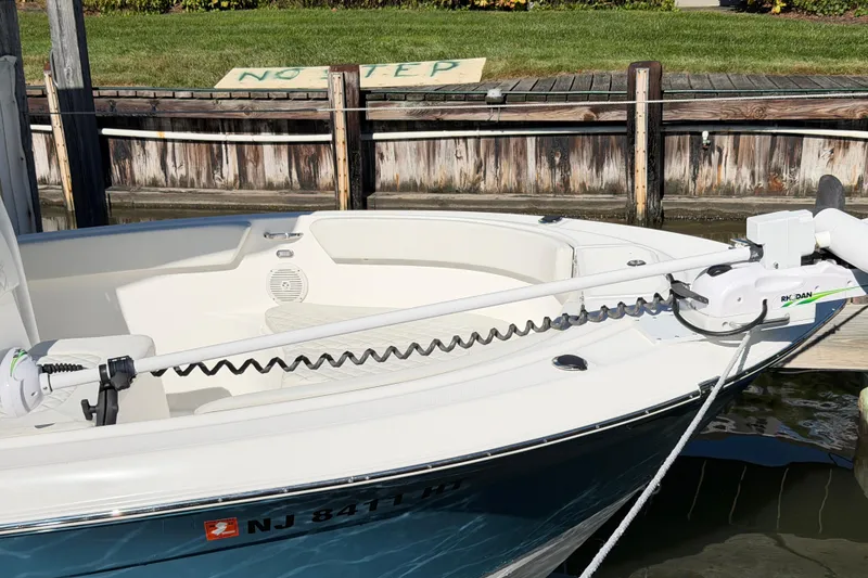 Slide: The Image of 2023 Clearwater 2200 CC boat docked, featuring a trolling motor and clean white interior. - 6
