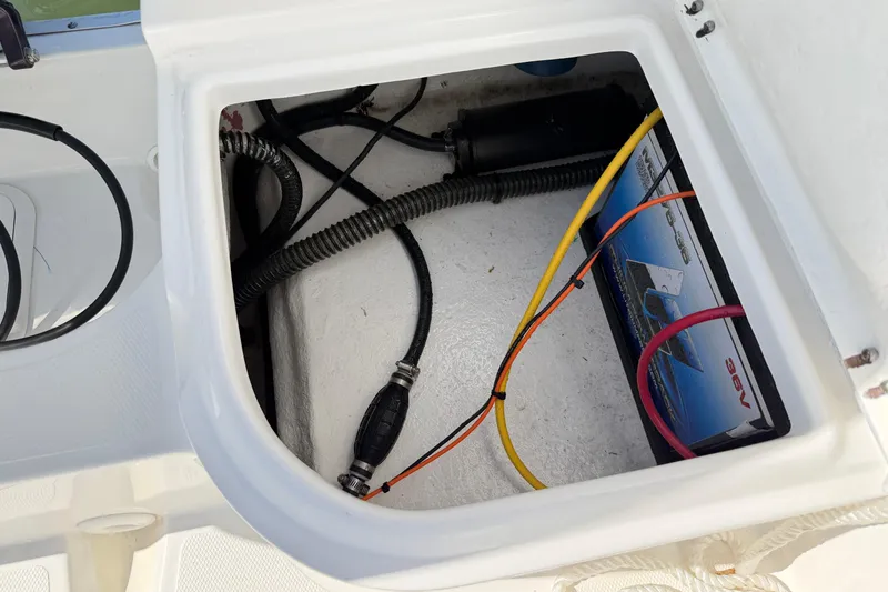 Slide: The Image of Open compartment of 2023 Clearwater 2200 CC boat showing wiring and battery setup. - 7