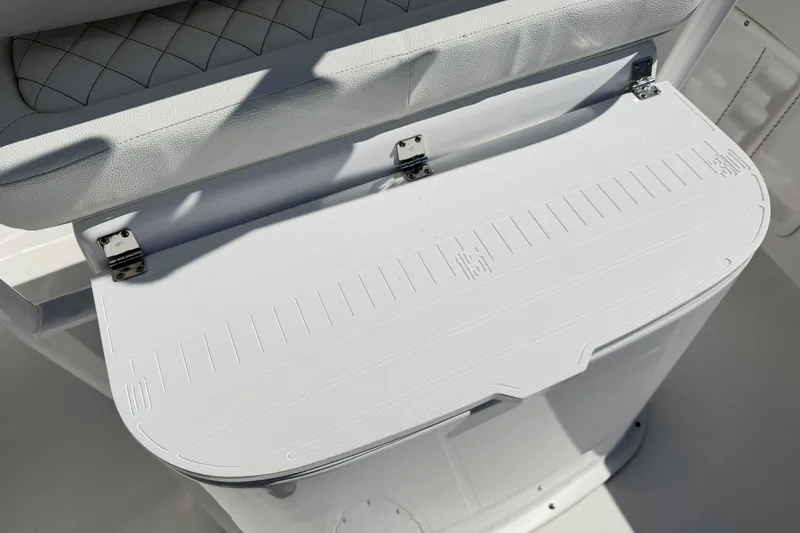 Slide: The Image of 2023 Clearwater 2200 CC boat seat with white cushioned backrest and storage compartment. - 8