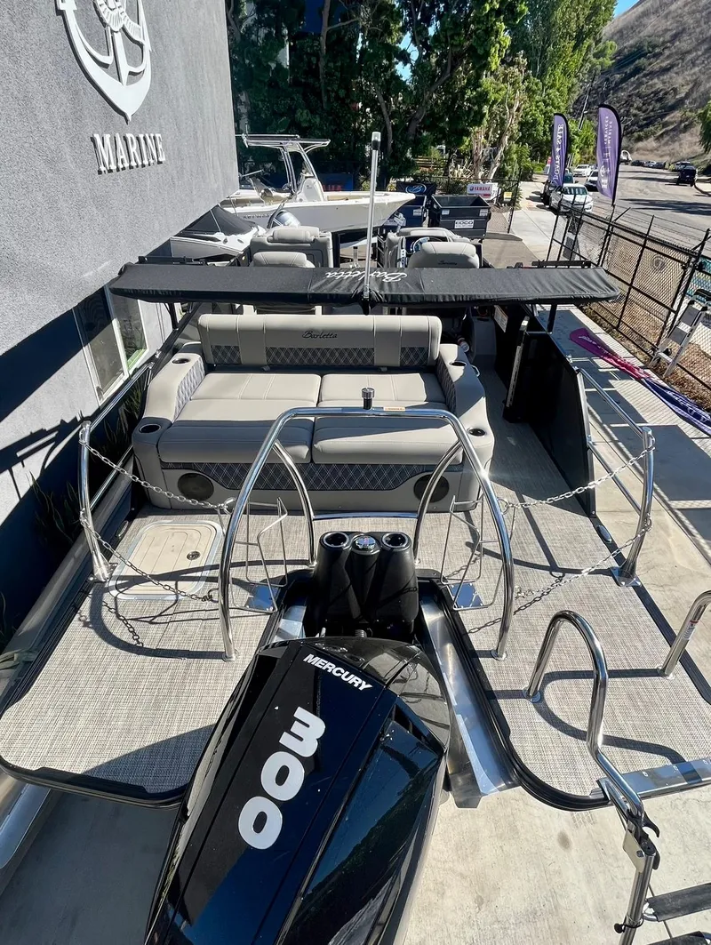 Slide: The Image of 2025 Barletta Lusso 23UC pontoon boat with Mercury 300 engine, docked outdoors. - 3