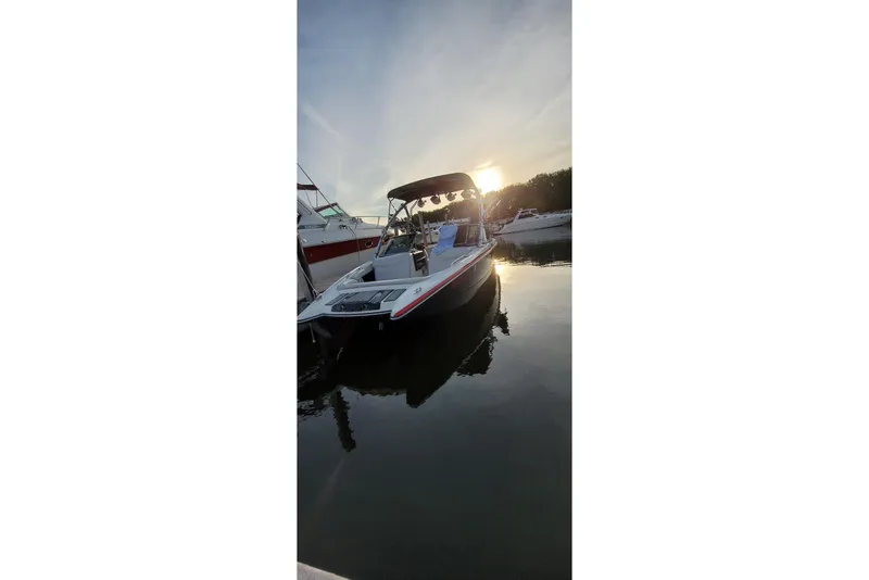 Slide: The Image of 2008 MasterCraft XStar 23 boat docked at sunset, reflecting on calm water. - 11
