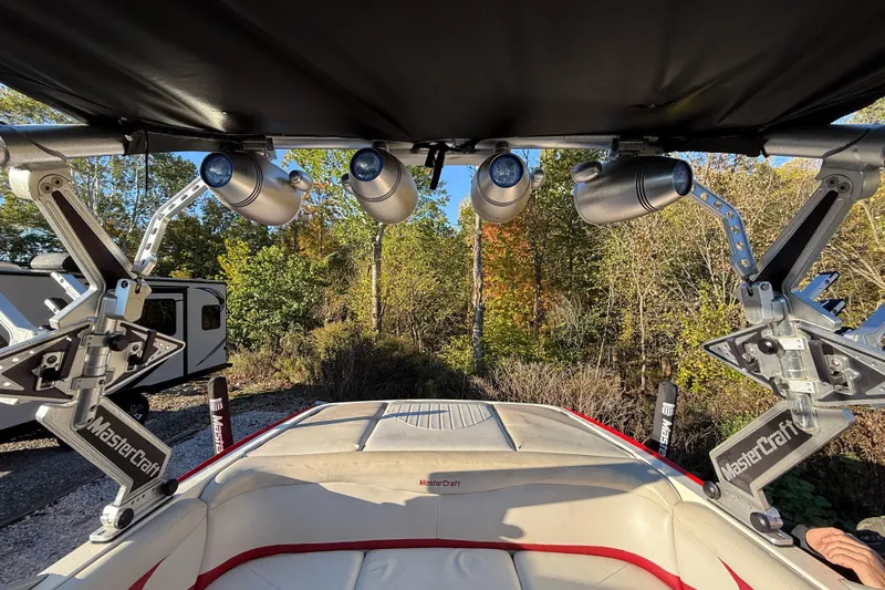 Slide: The Image of 2008 MasterCraft XStar 23 boat interior with speakers and canopy, surrounded by trees. - 12