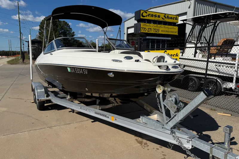 Slide: The Image of 2019 Stingray 198 LX boat on trailer at dealership, sunny day. - 1