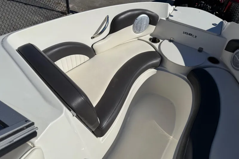 Slide: The Image of 2019 Stingray 198 LX boat interior with black and white seating and cup holders. - 12